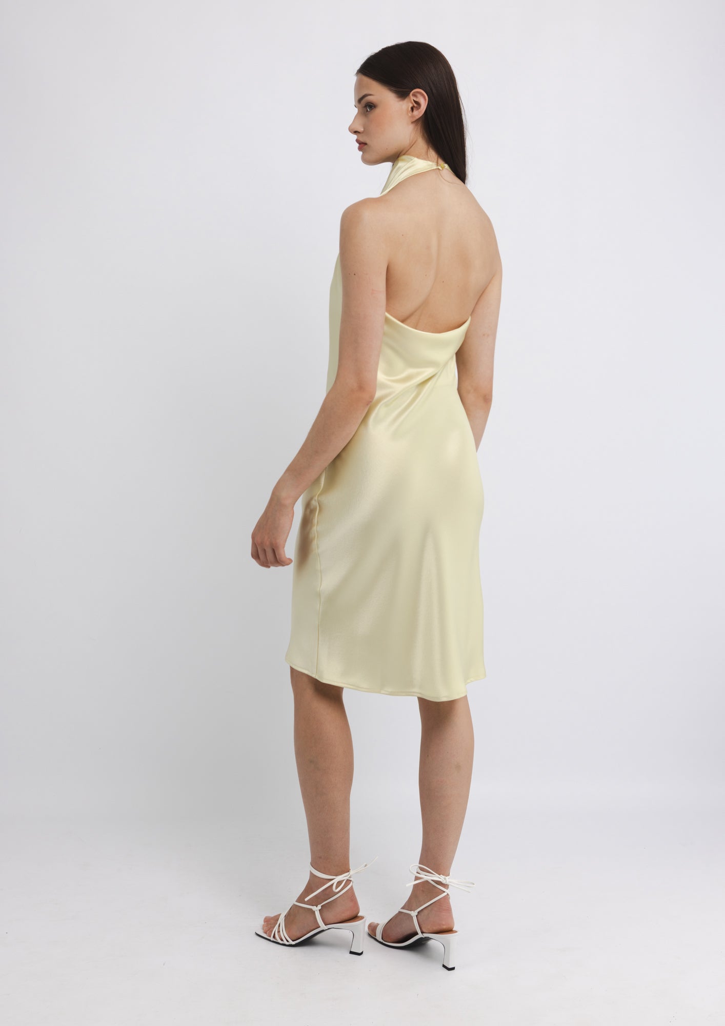 Woman wearing a light yellow dress on a white background