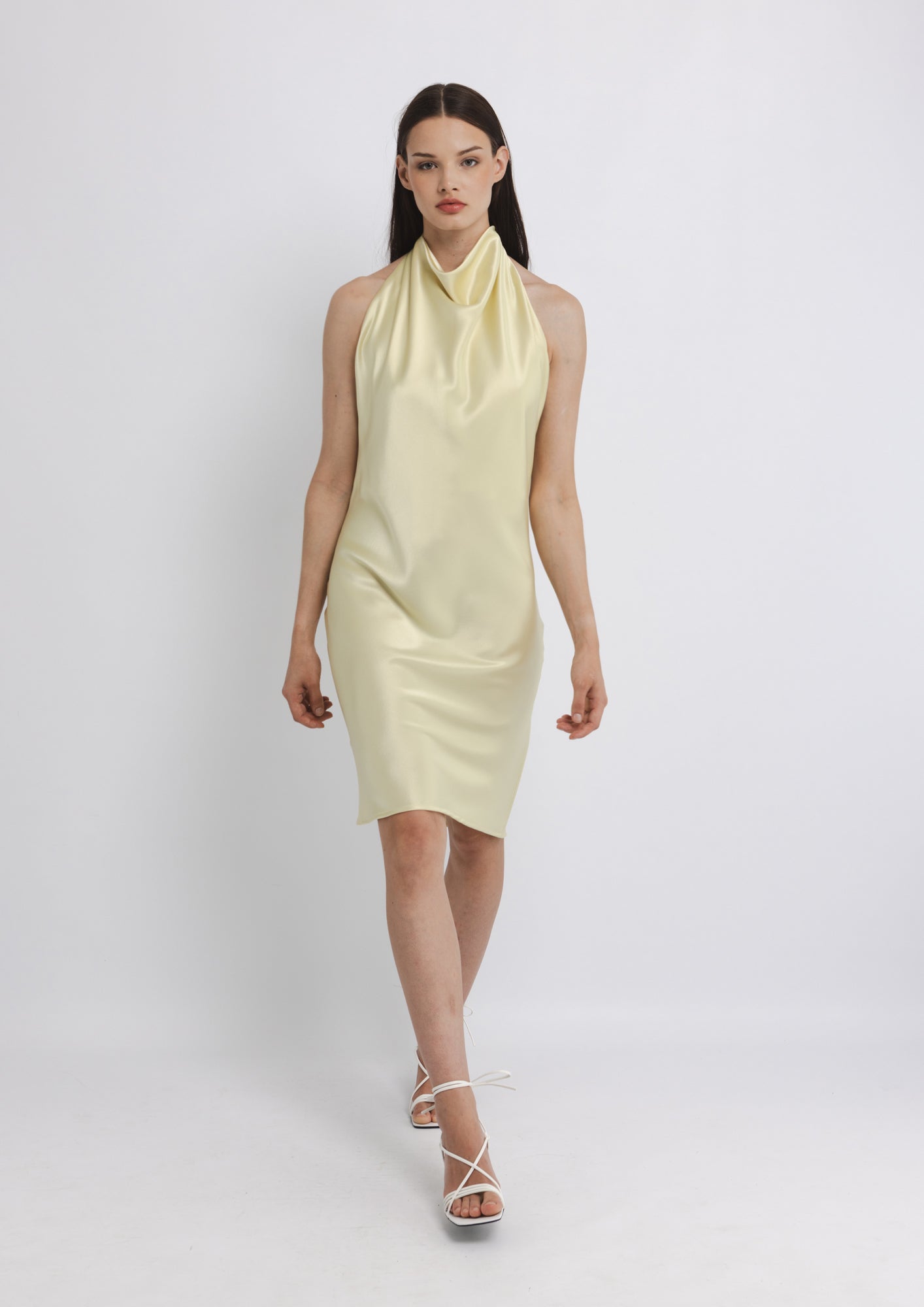 Woman wearing a light yellow dress on a white background