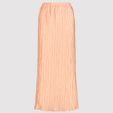 Peachy pleated skirt on a light gray background