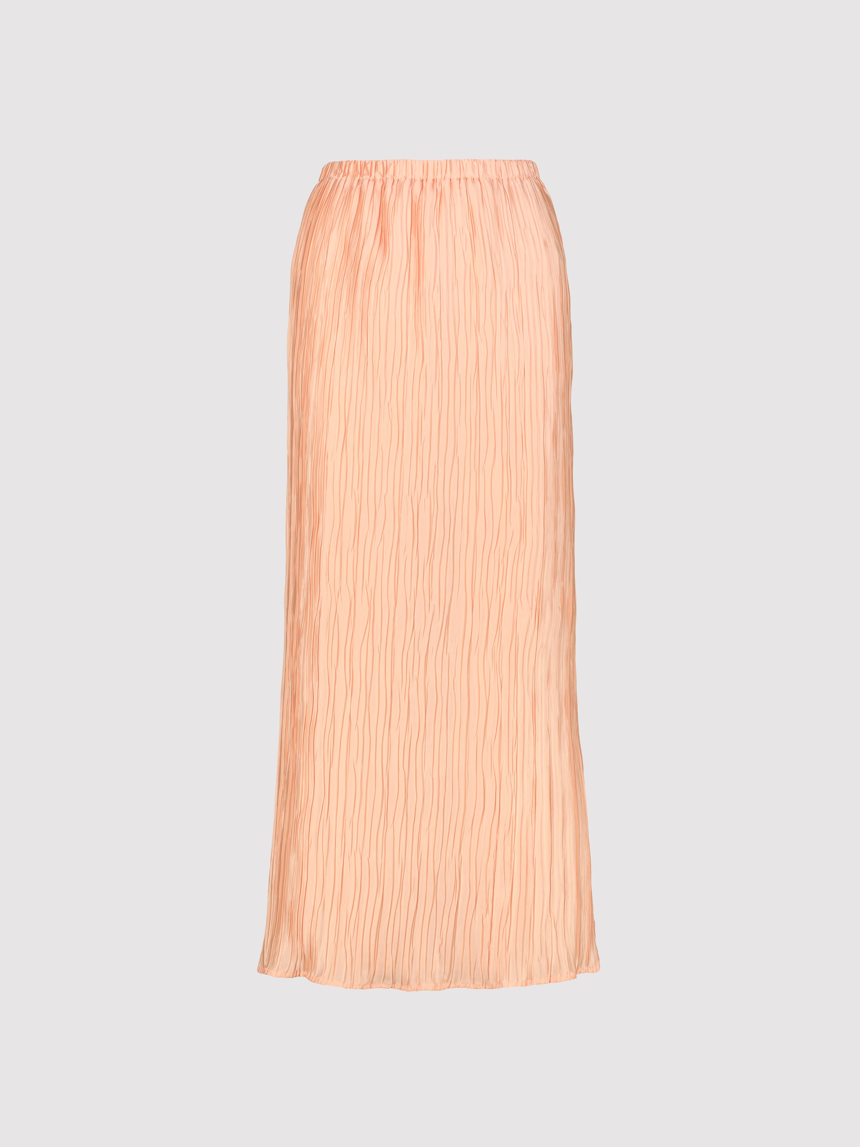 Peachy pleated skirt on a light gray background
