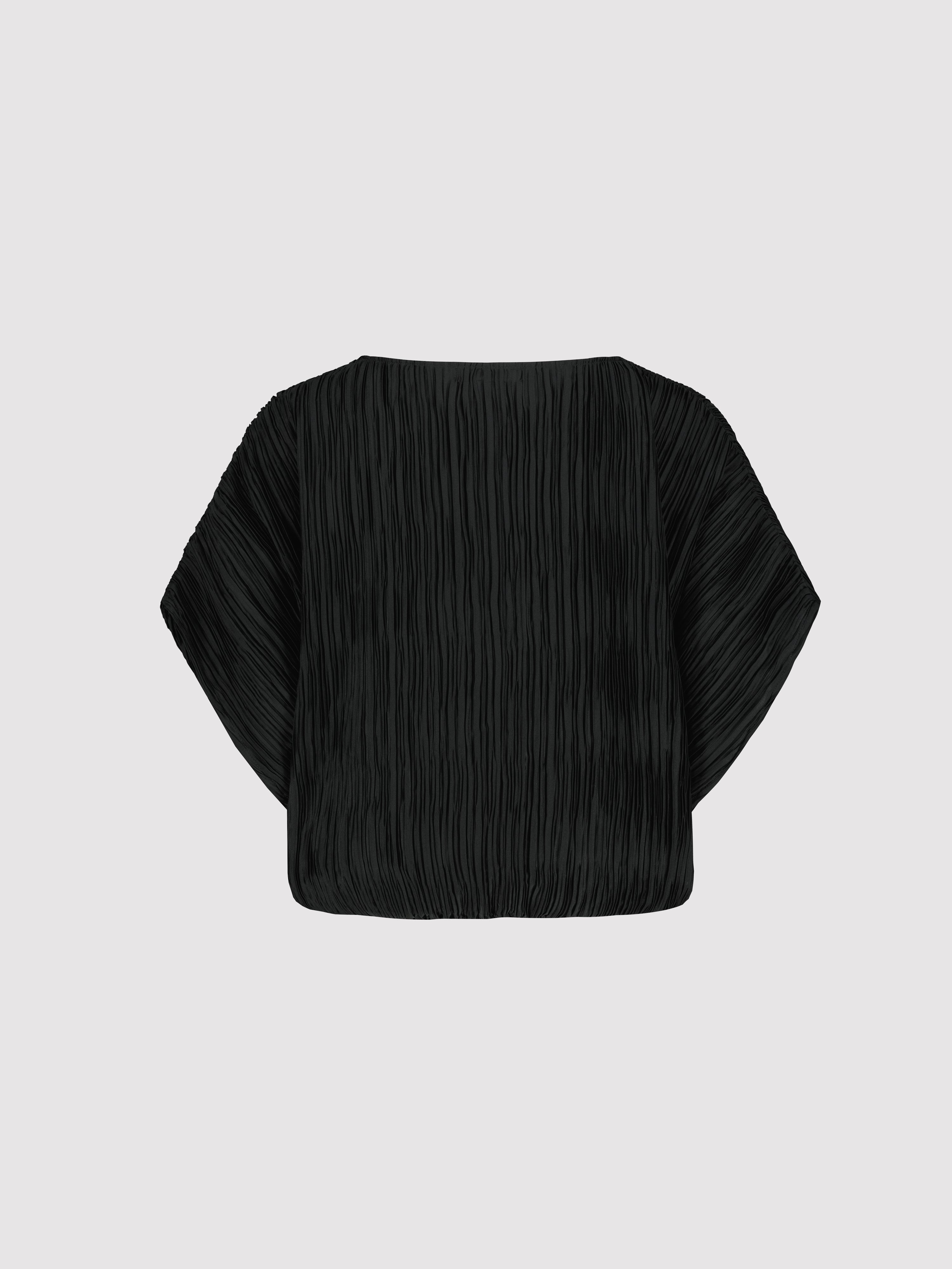 Black pleated blouse on a light gray background