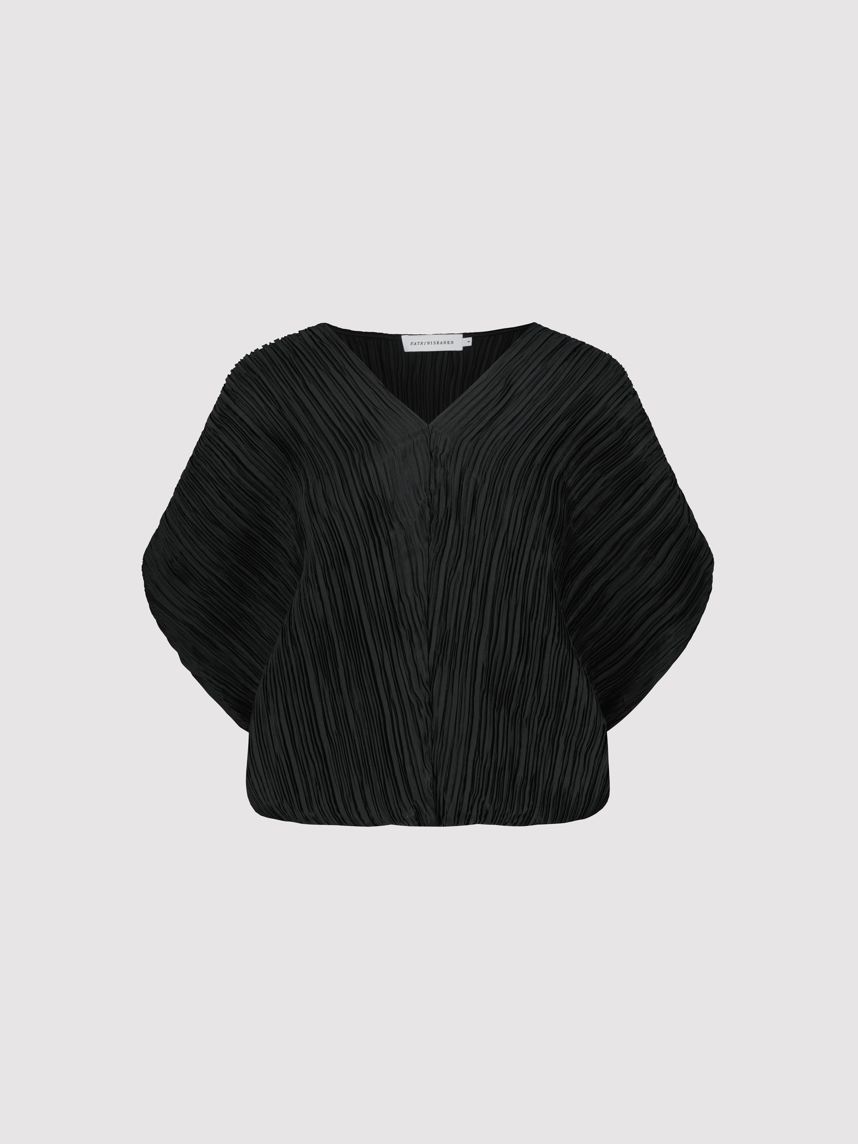 Black pleated blouse on a light gray background