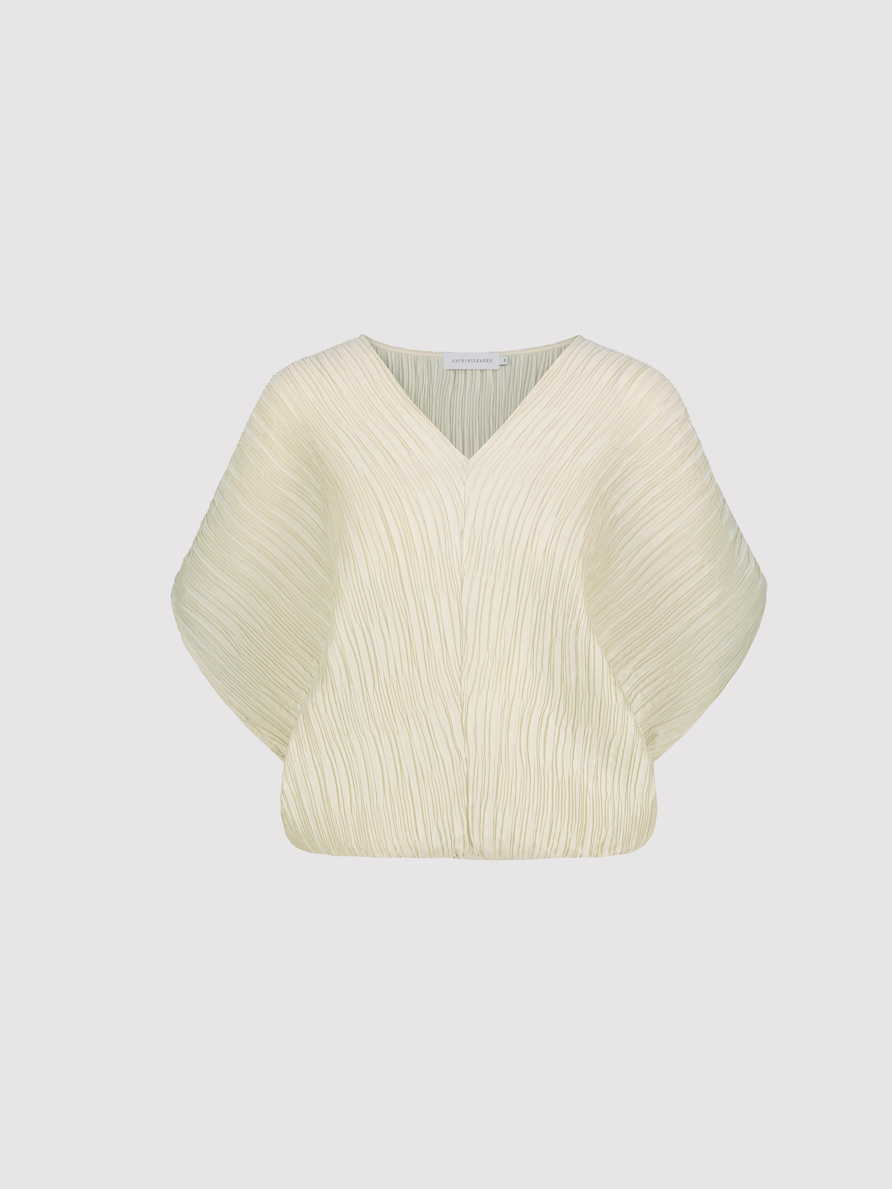 Cream-colored plisse top on a light gray background